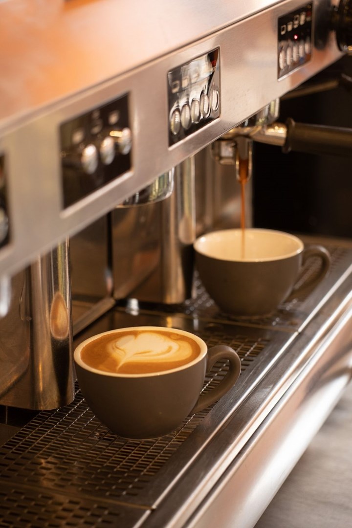 Máquina de café expreso con dos tazas de café