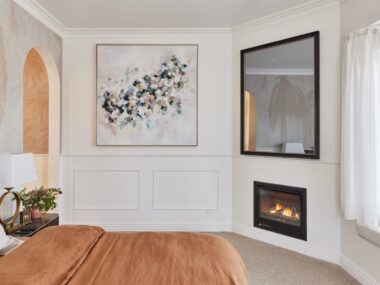 bedroom with in built gas fireplace and pink bedspread